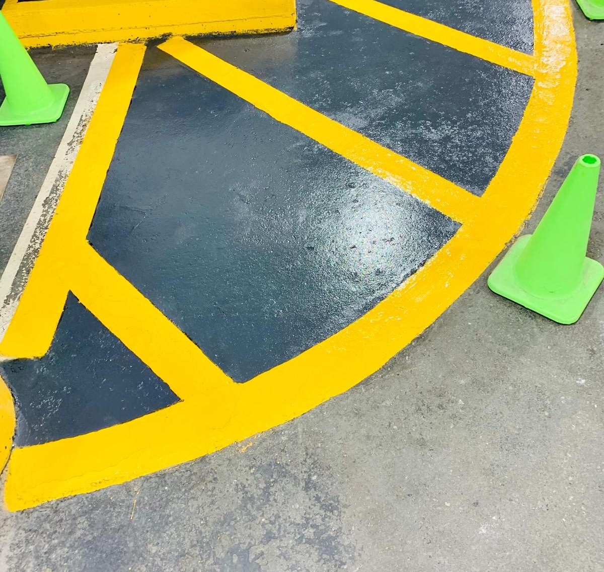Fresh yellow high-visibility safety lines on a coated parking surface