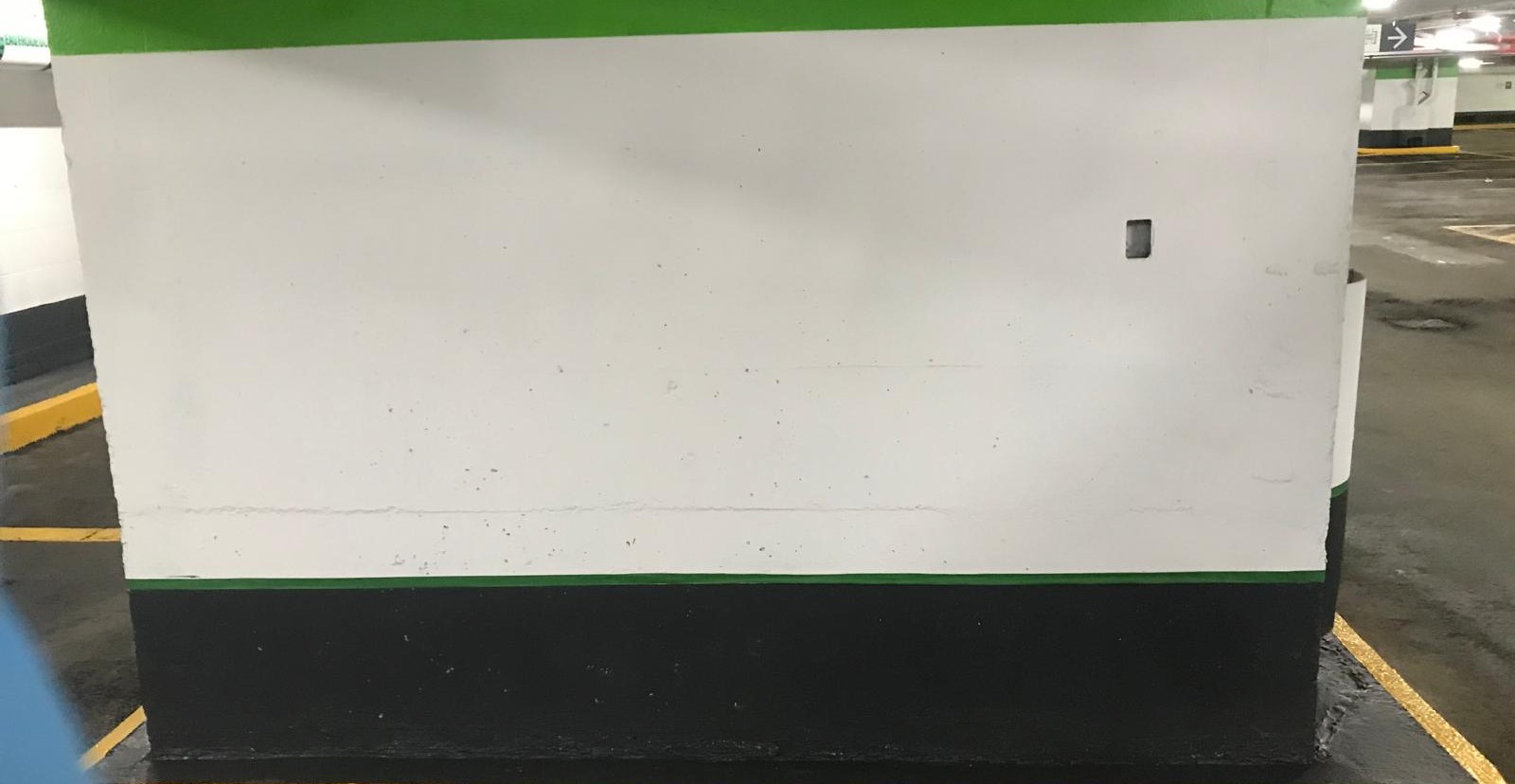 Large white commercial parking wall with dark finished base